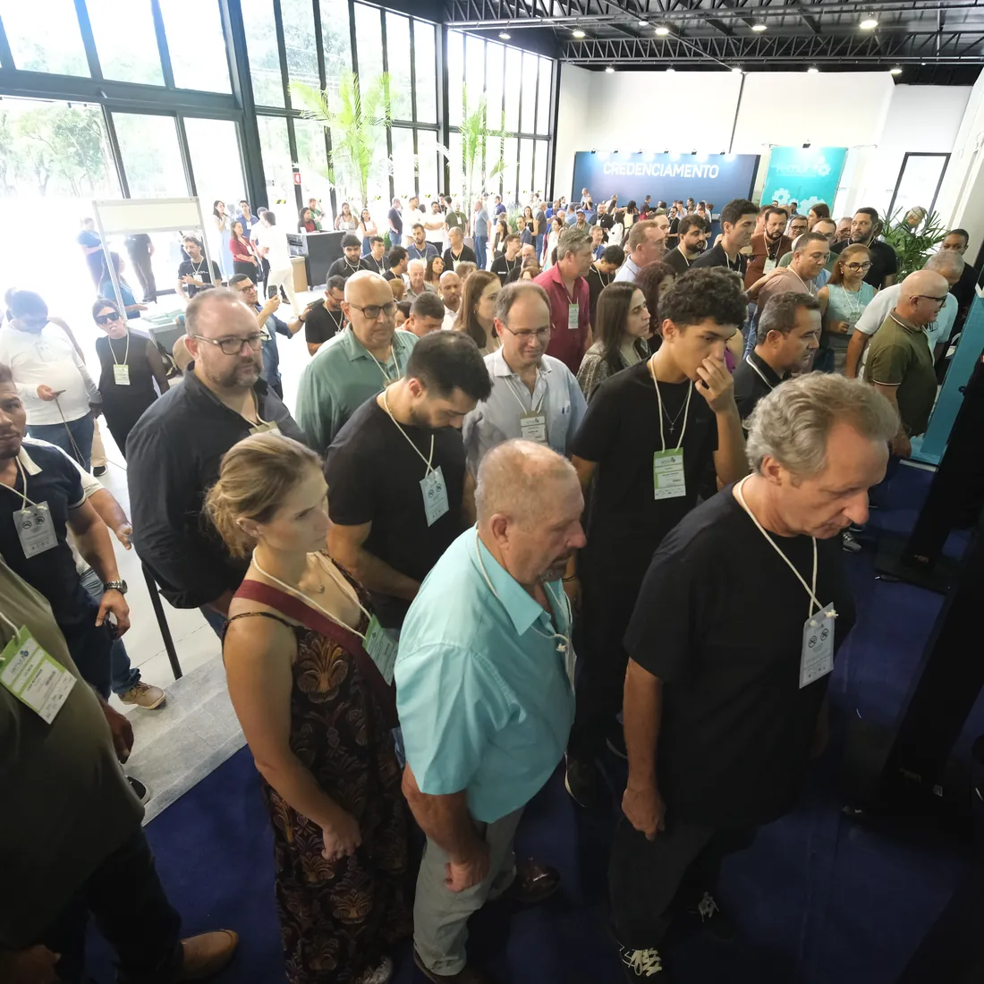 Lojistas com a credencial no pescoço passam pelas catracas do hall da FEMUR 2026