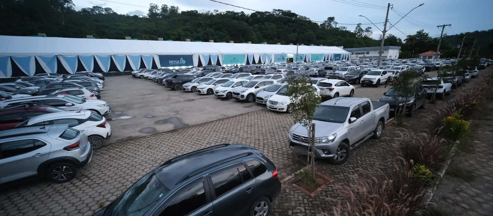 O estacionamento do pavilhão cheio durante a FEMUR 2026, com o anexo ao fundo.