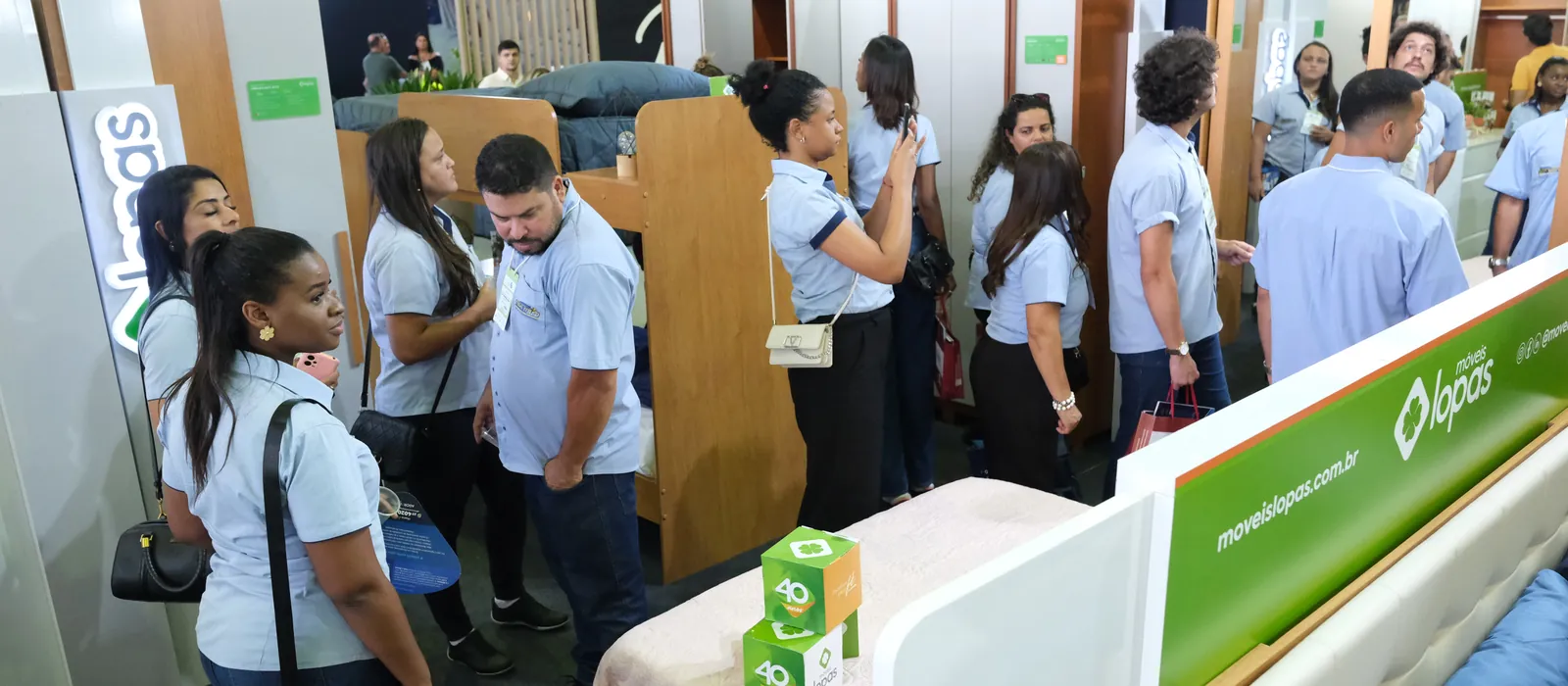 Estande montado de uma indústria, com a equipe recebendo lojistas na FEMUR 2026