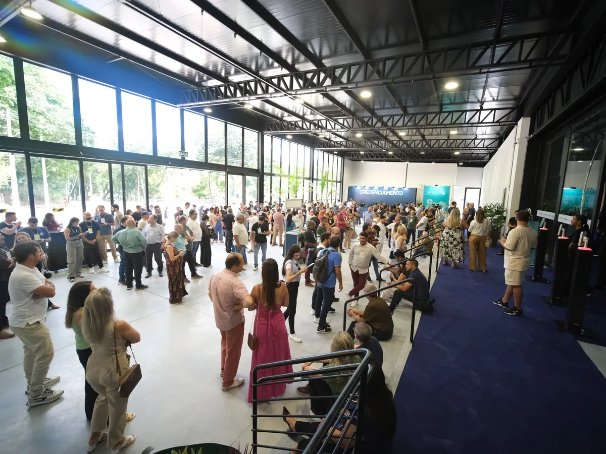 O hall de entrada, refeito em 2026, com o credenciamento ao fundo e o público chegando.