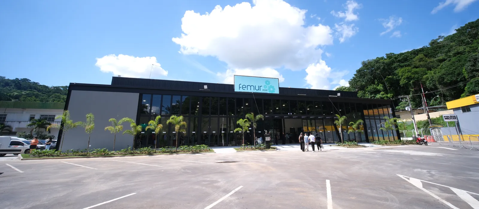 A fachada de vidro do hall de entrada do Pavilhão Irineu Gomes Filho, num dia de céu aberto.