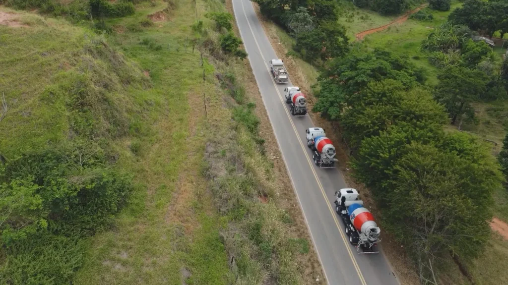 Comboio de caminhões-betoneira da MBC na rodovia, visto do alto