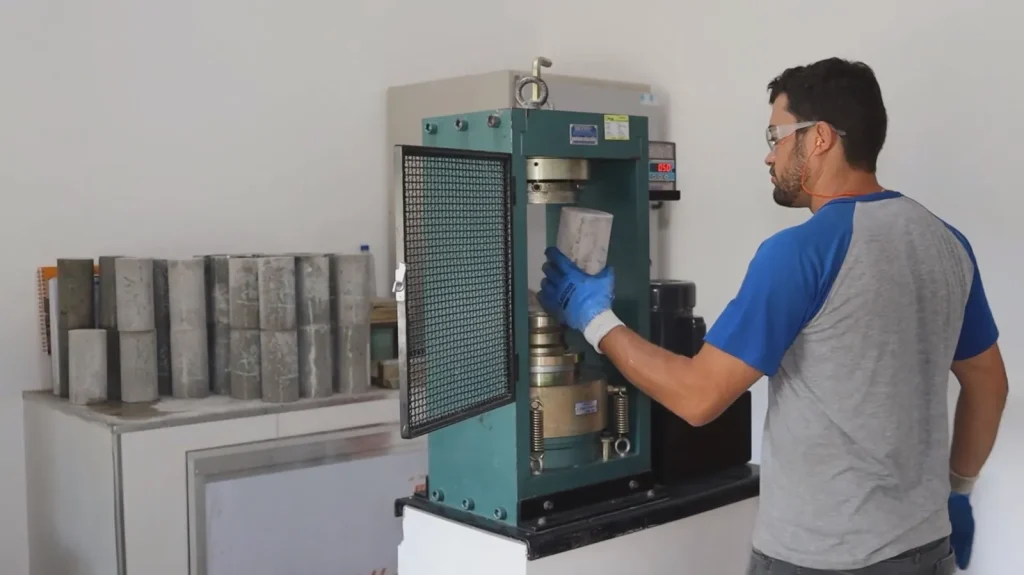 Técnico do laboratório da MBC operando a prensa de ruptura de corpos de prova