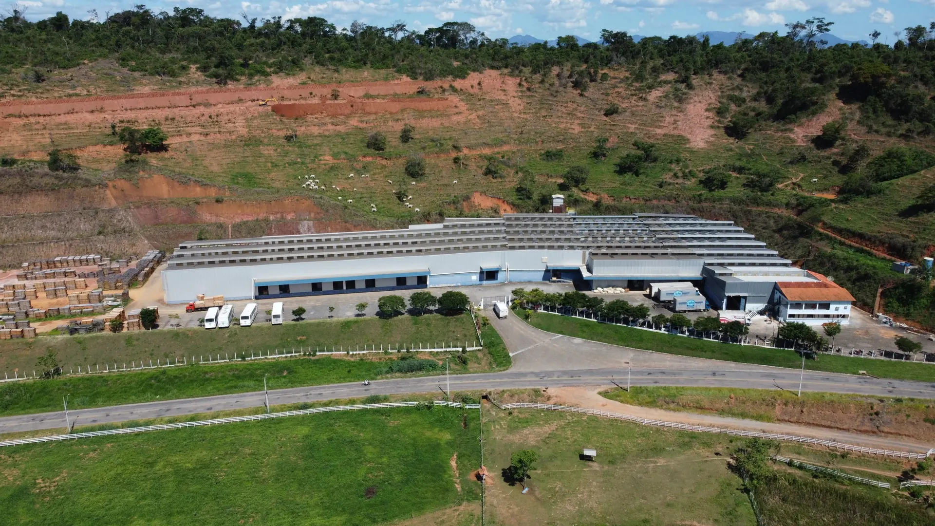 Vista aérea da fábrica da Lufer Estofados, na Rodovia Ubá–Divinésia, com os galpões e a serra ao fundo