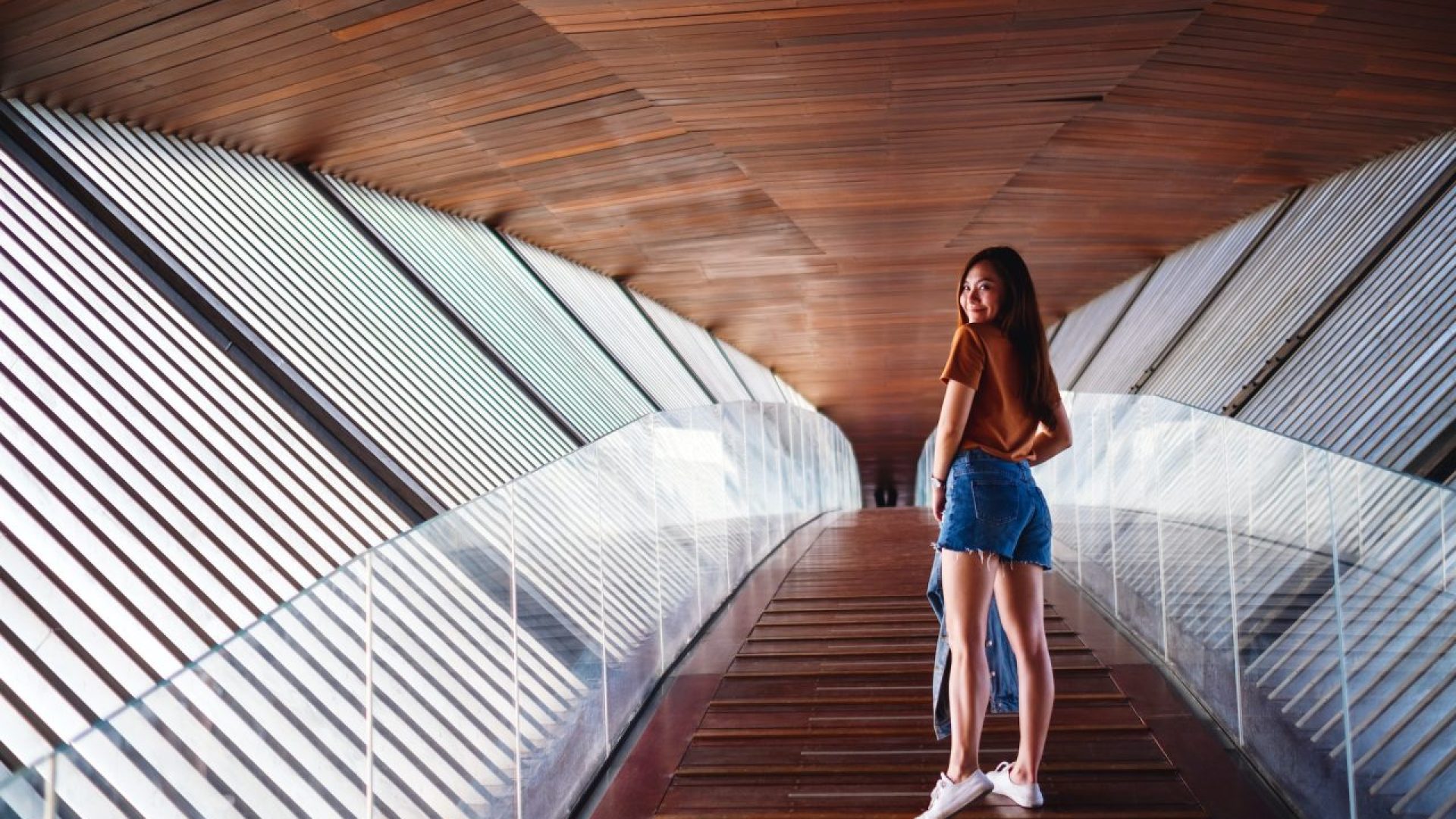 a-young-asian-woman-walking-inside-a-modern-wooden-building.jpg